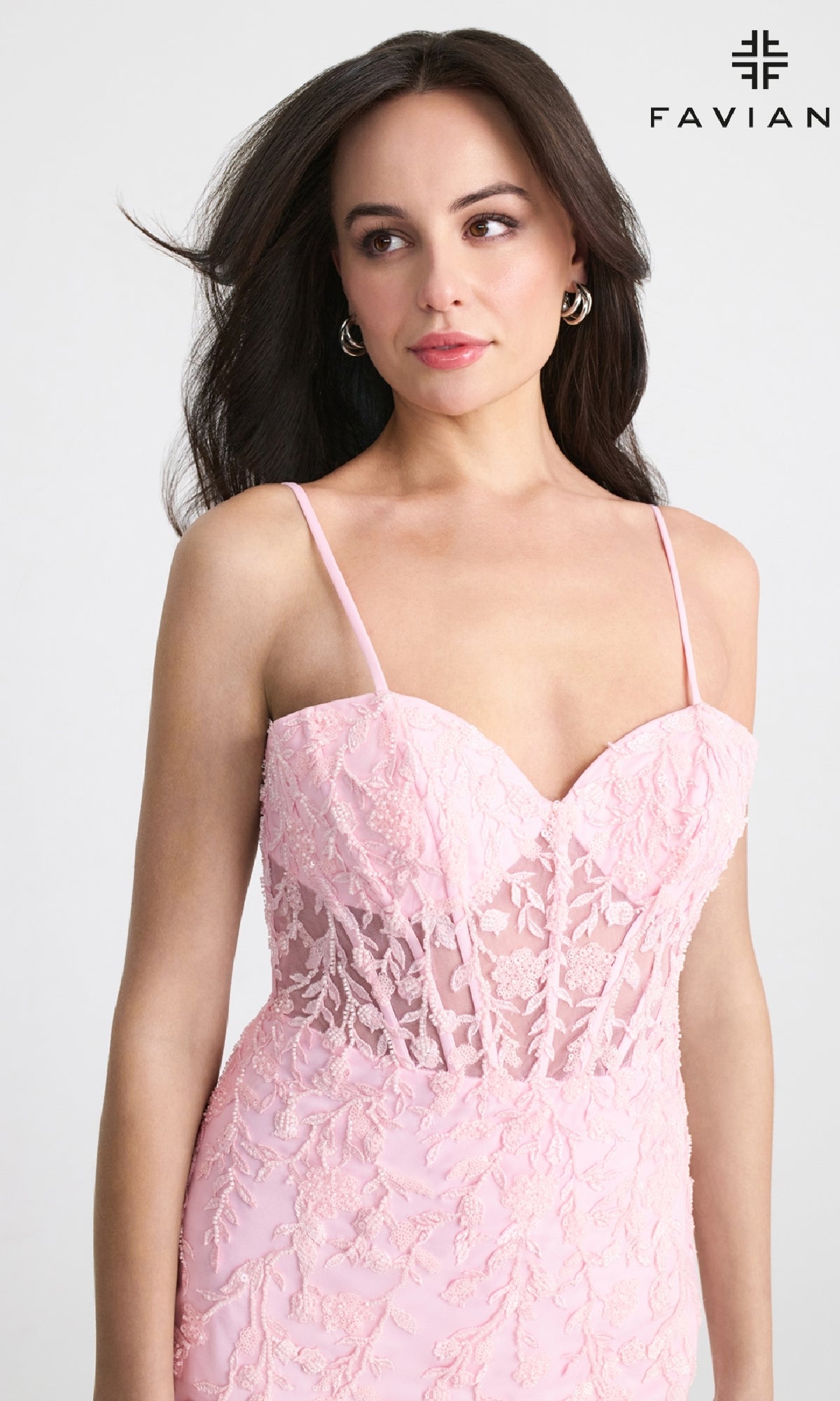 A woman models the Sheer-Bodice Short Lace Hoco Dress: Faviana 11304, featuring thin straps and a sheer bodice, standing against a plain background with the